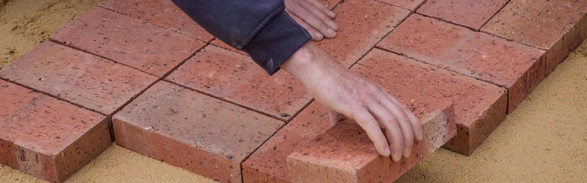 Pose de pavés sur lit de pose, surface extérieure en cours de réalisation